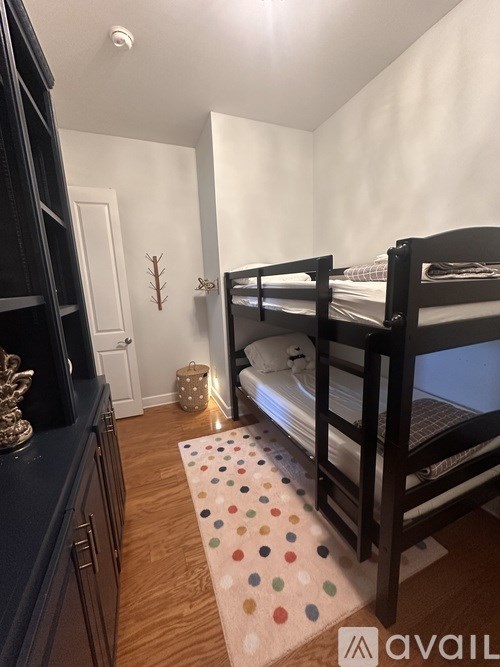 A room with a bunk bed and a polka dot rug.