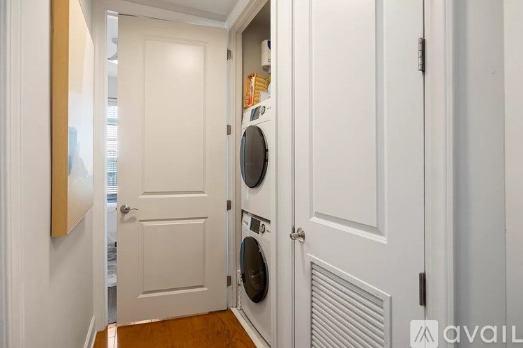 A white door is open to a laundry room with a washer and dryer.