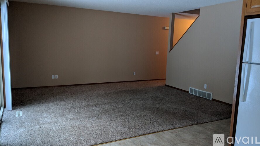 A room with a carpeted floor and a wall with a triangular cutout.
