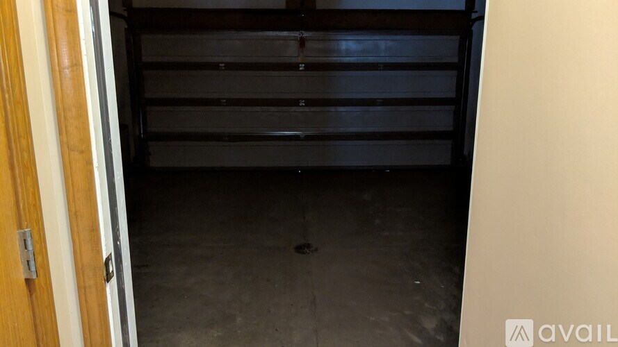 A dark garage with a wooden door and a wall.