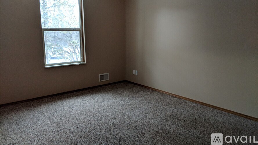 A room with a carpeted floor and a window.