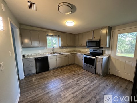 A kitchen with a microwave, oven, and sink.