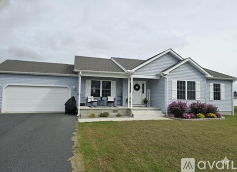 A house with a grey roof and a white garage door.