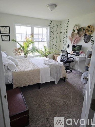 A bedroom with a bed, desk, and chair.