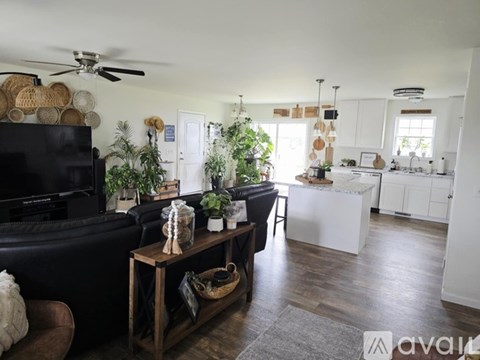 A living room with a black couch and a wooden coffee table.