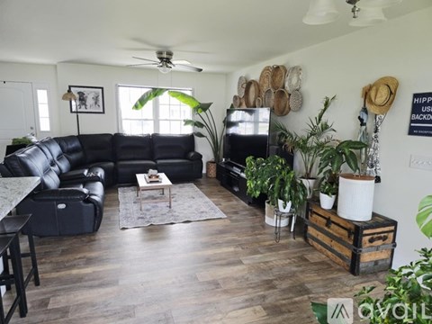 A living room with a black leather sofa and a coffee table.