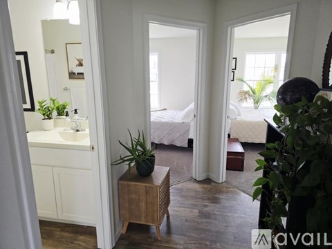 A bathroom with a sink, mirror, and a wooden stool.