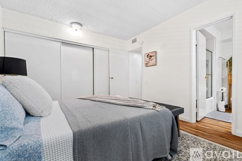 A bedroom with a bed and a wall-mounted air purifier.