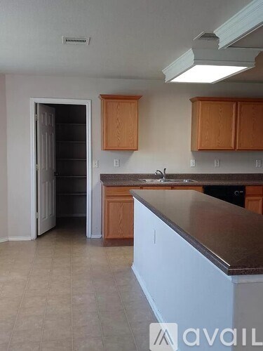 A kitchen with brown cabinets and a white counter.