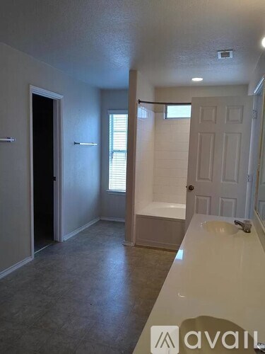 A bathroom with a white counter and a white door.