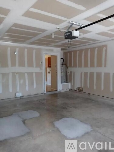 A room with a white ceiling and walls, with a doorway leading to another room, and a camera mounted on the ceiling.