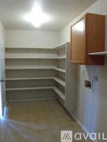 A room with a white wall and a brown cabinet.