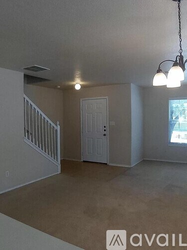 A room with a white door and a window with a view of a street.