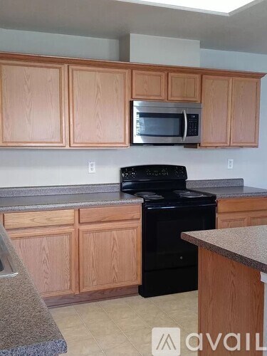 A kitchen with wooden cabinets and black appliances.
