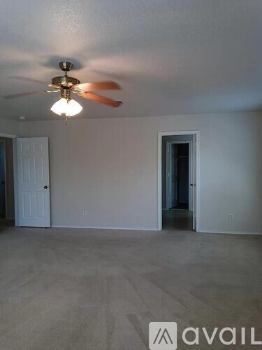 A room with a ceiling fan and two doors.