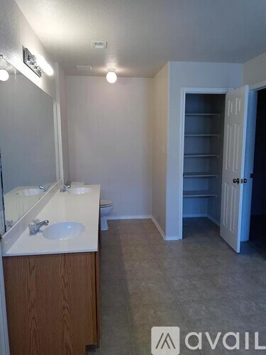 A bathroom with a sink, mirror, and toilet.