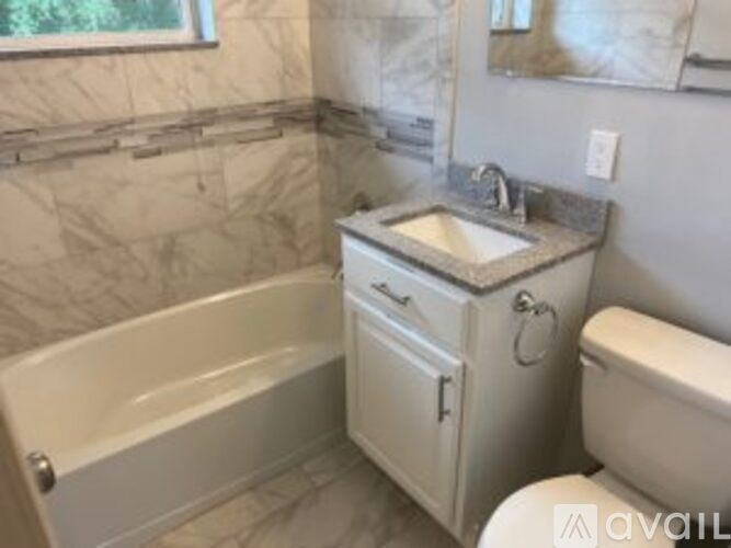 A bathroom with a tub, toilet, and sink.