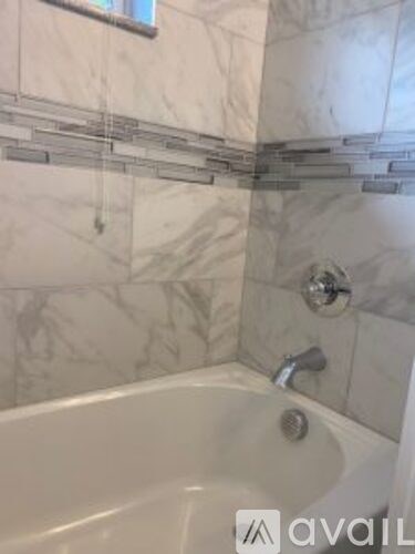 A bathroom with a tub and a shower head.