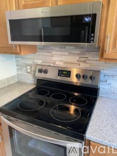 A modern kitchen with a stove top oven and microwave above it.