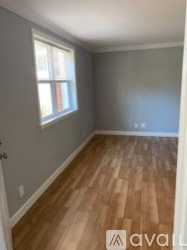 A room with wooden flooring and a window.