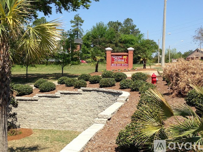 A sign with a phone number is in front of a house.