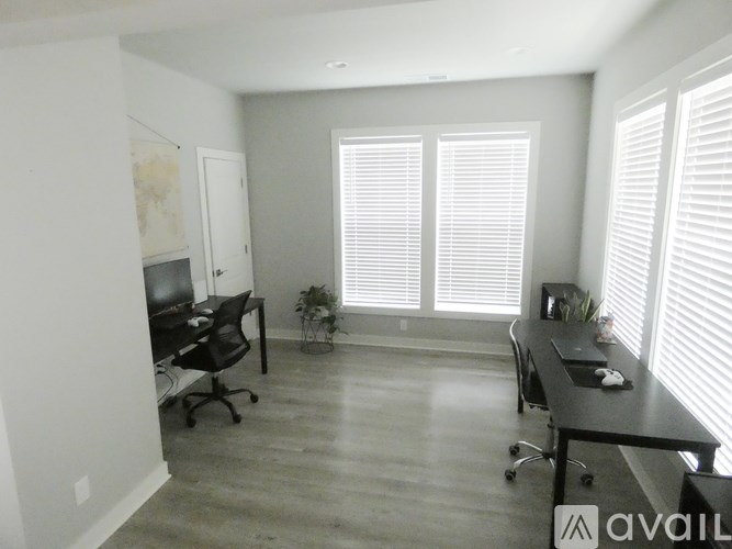 A room with a desk, chairs, and a map on the wall.