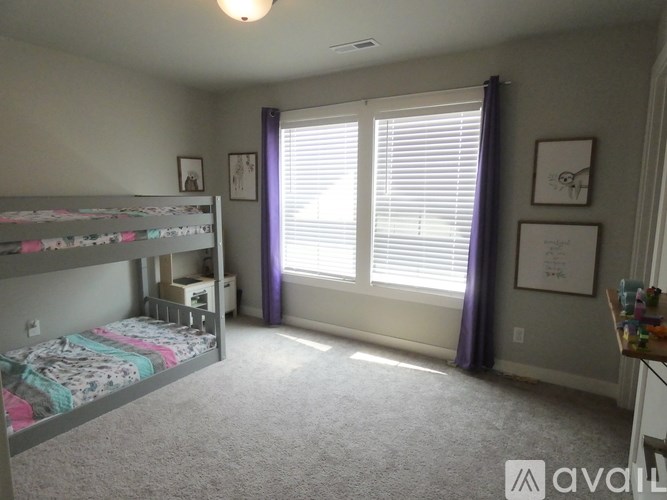 A bedroom with a bunk bed and a window with blinds.