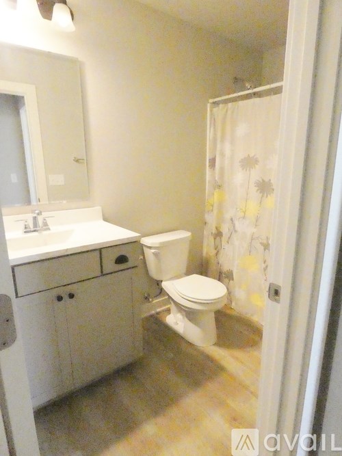A white toilet sits in a bathroom next to a sink.