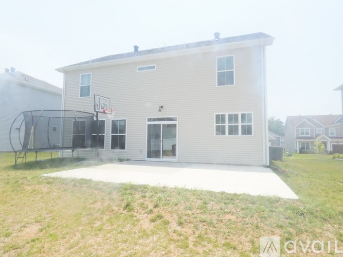 A house with a basketball hoop in the backyard.