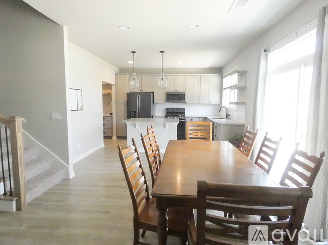 A dining room with a wooden table and chairs.