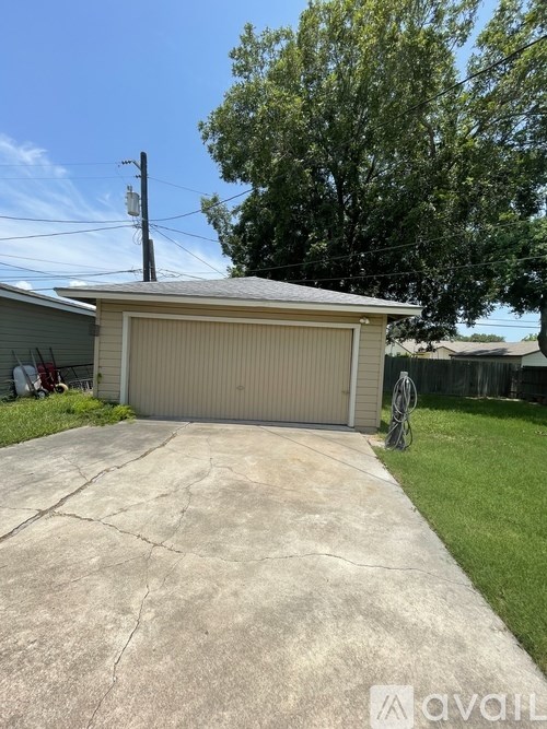 A detached garage with a concrete driveway in front.