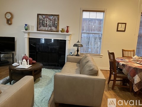 A living room with a fireplace and a painting on the wall.