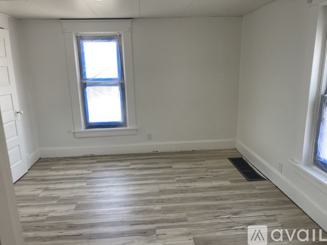 A room with a window and wooden flooring.