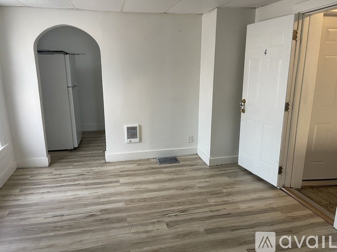 A room with a wooden floor and a white door.
