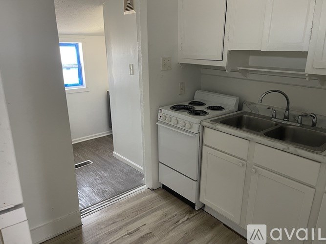 A kitchen with white appliances and cabinets.