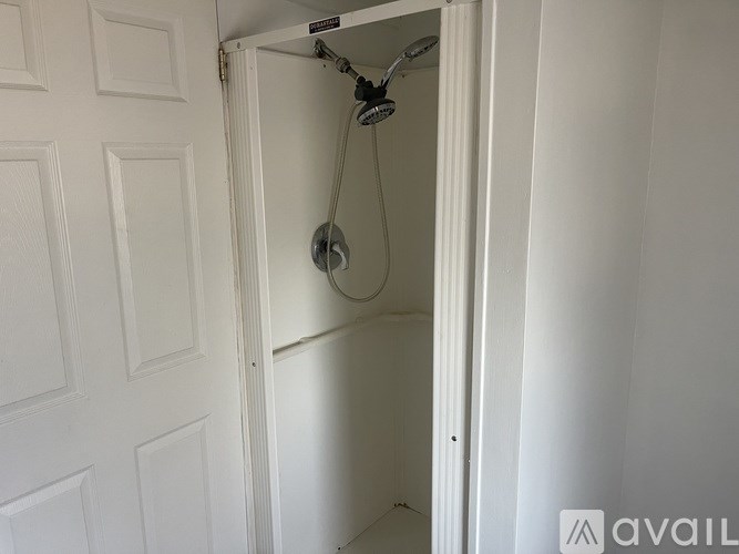 A white door with a shower head attached to it.