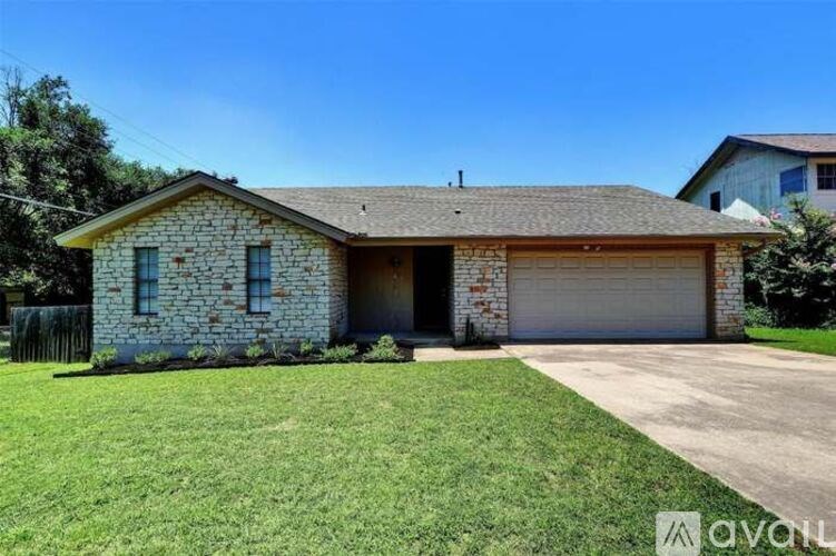 A house with a stone facade and a brown roof is for sale.