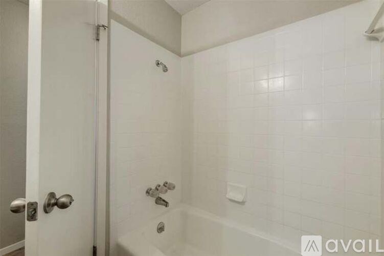 A white bathroom with a shower and a door.