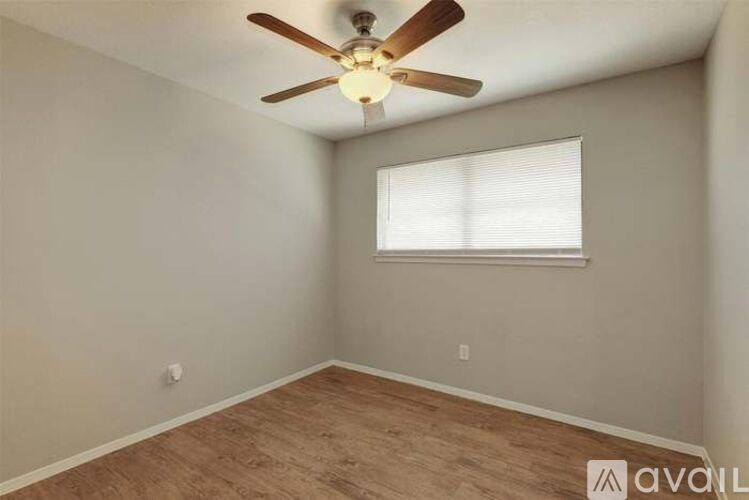 A room with a ceiling fan and a window.