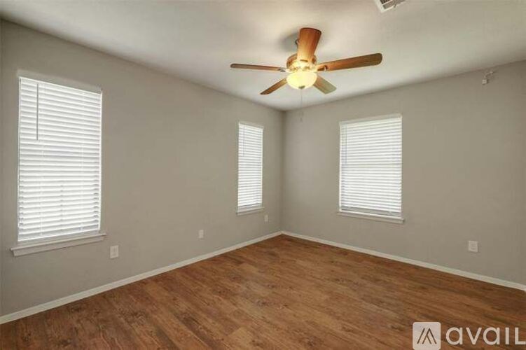 A room with wooden flooring and a ceiling fan.
