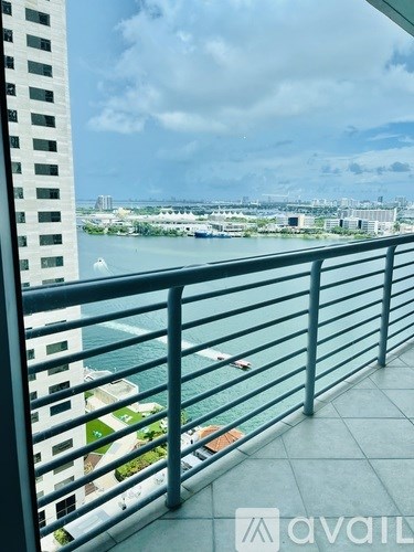 A balcony with a metal railing overlooking a body of water with boats.