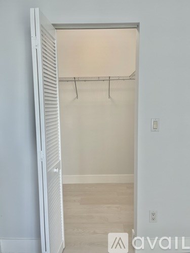 A white closet with a shelf and a hanger.