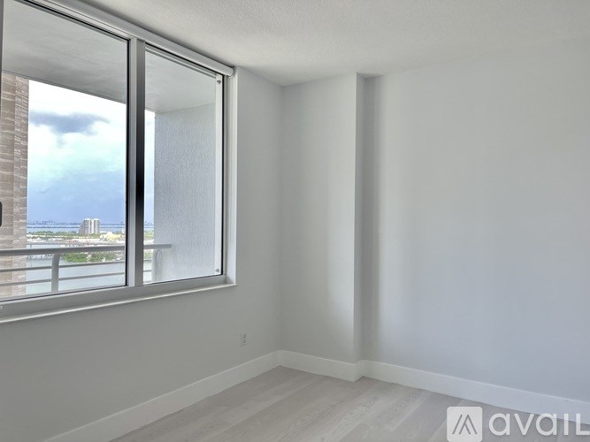 A room with a large window overlooking a body of water.