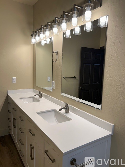 A bathroom with a vanity, sink, and mirror.