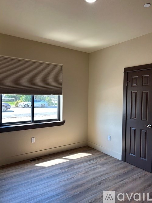 A room with a window and a door is available for rent.