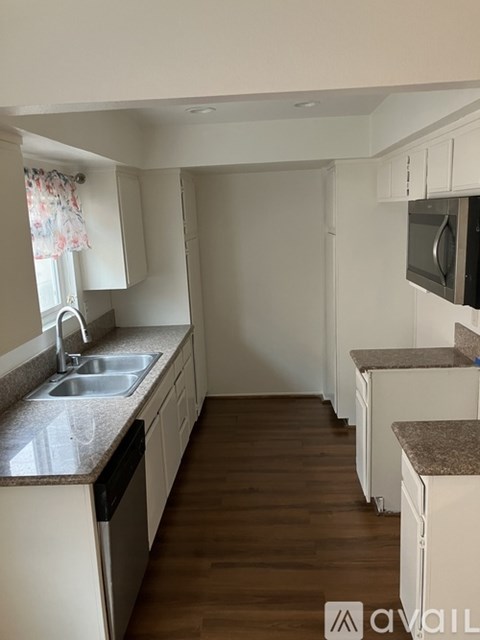 A kitchen with white cabinets and a granite countertop.