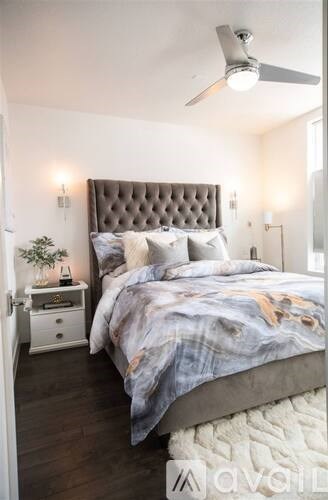 A bedroom with a large bed and a ceiling fan.