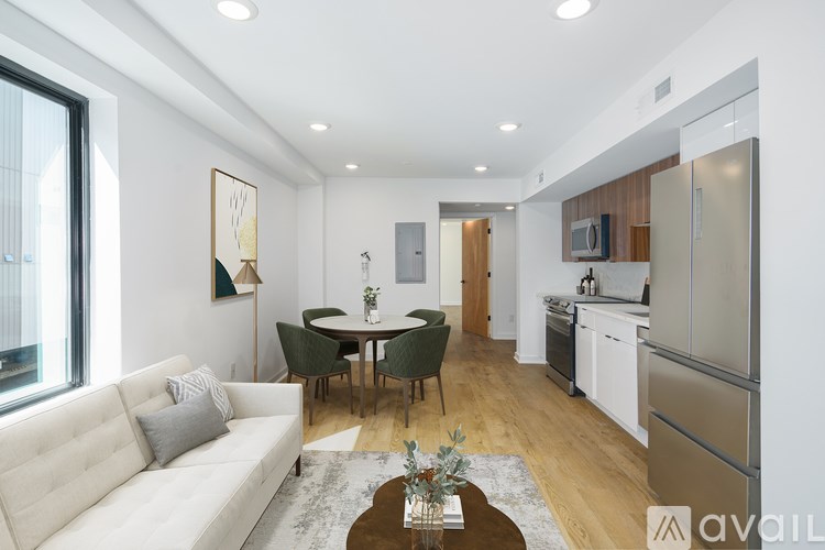 A modern kitchen with a white refrigerator and a dining table with chairs.