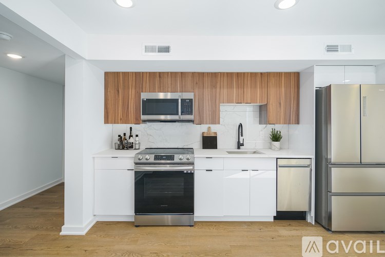 A modern kitchen with white cabinets and a wooden backsplash.