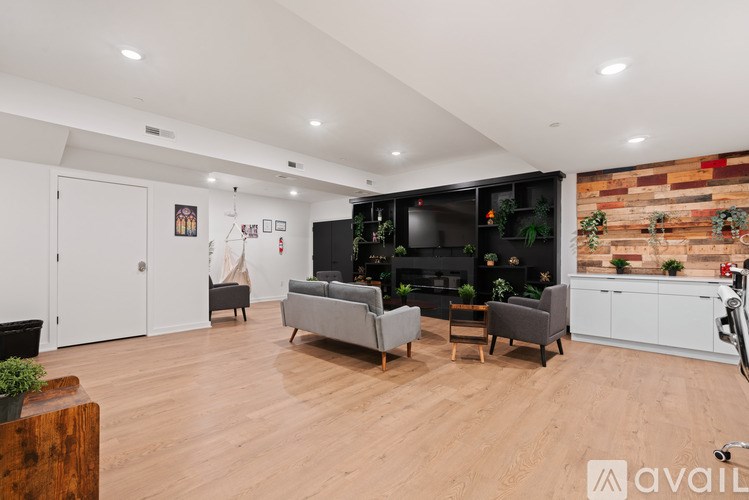 A living room with a grey couch and a wooden floor.